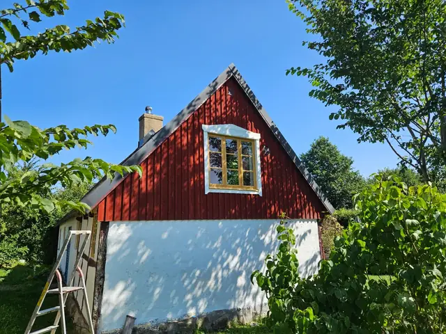 Varsamt renoverat hus på Österlen med rödmålad panel och korsvirke